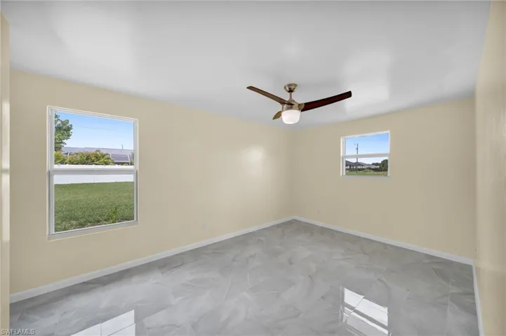 Empty room with a ceiling fan and baseboards