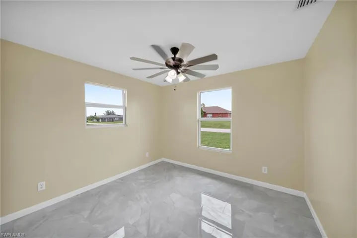 Unfurnished room featuring ceiling fan and marble finish flooring