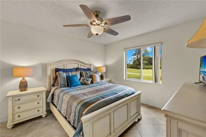Primary bedroom with tiled flooring and ceiling fan