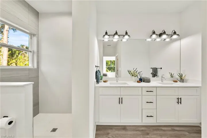 Bathroom with vanity, LVP flooring, and walk in shower