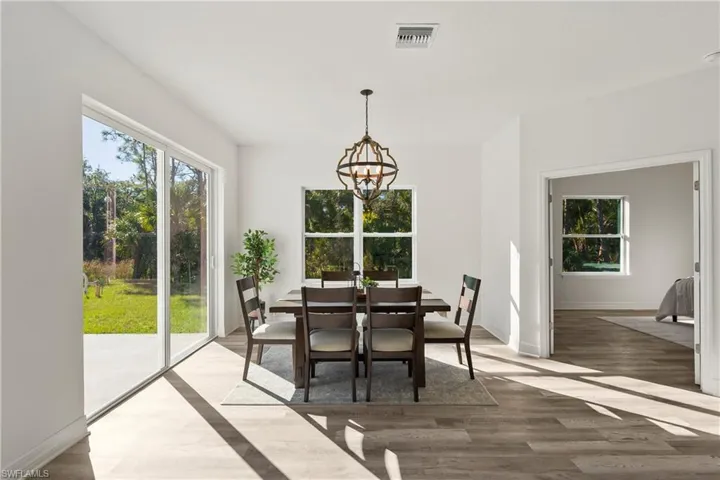 Dining room featuring a wealth of natural light, a chandelier, and LVP flooring.