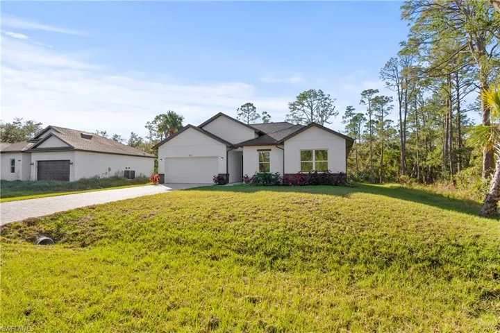 View of front facade featuring a front yard and a garage