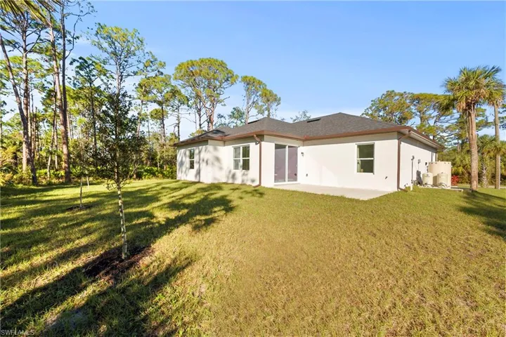 Back of property with a lawn and a patio