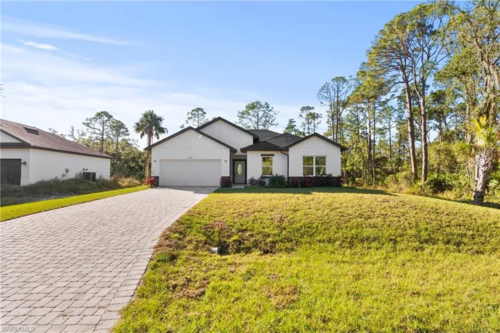 View of front of house featuring a front lawn and a garage