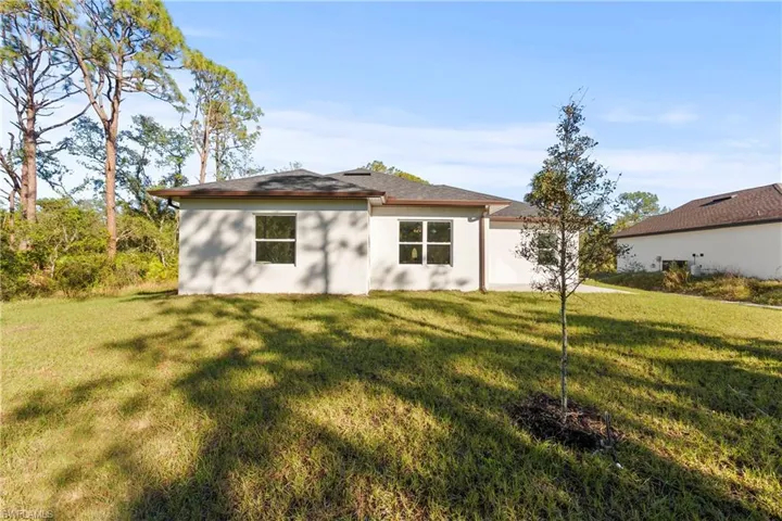 Rear view of house featuring a lawn