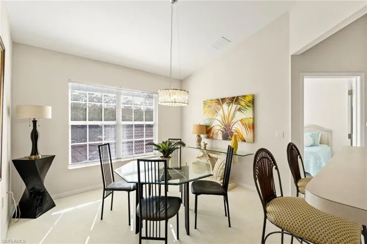 Dining area featuring a contemporary chandelier, multiple paned windows, and a vaulted ceiling
