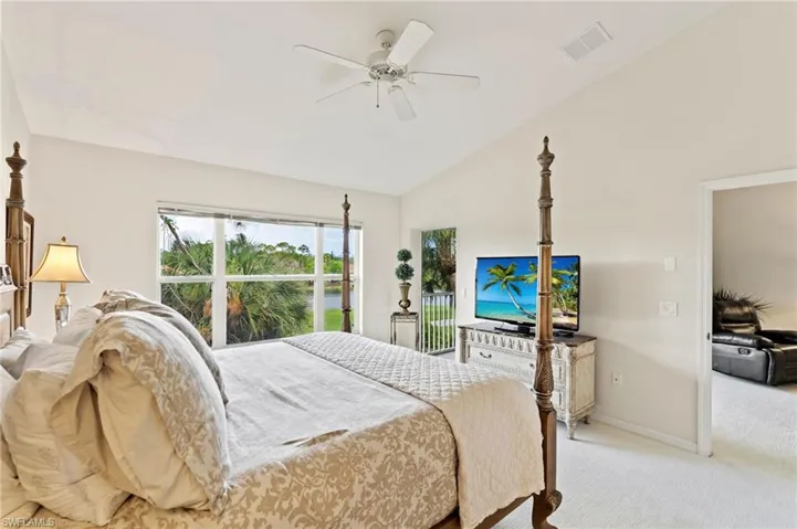 Vaulted ceilings complement the large window overlooking lush tropical foliage and a body of water
