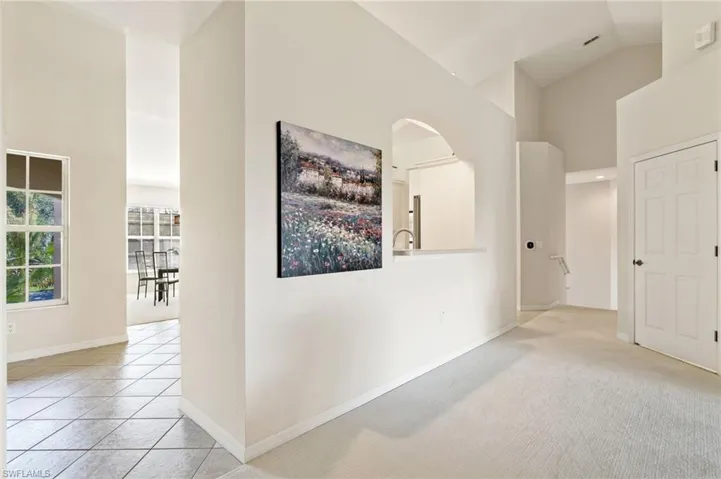 Interior architectural details featuring vaulted ceilings and an arched pass-through window