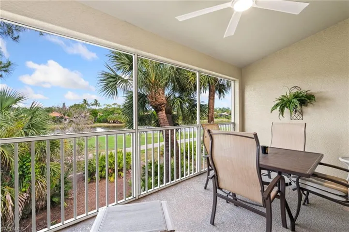 Screened balcony featuring a ceiling fan, textured walls, and a durable flooring surface