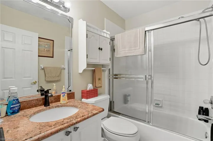 Full bath with combined bath / shower with glass door and vanity