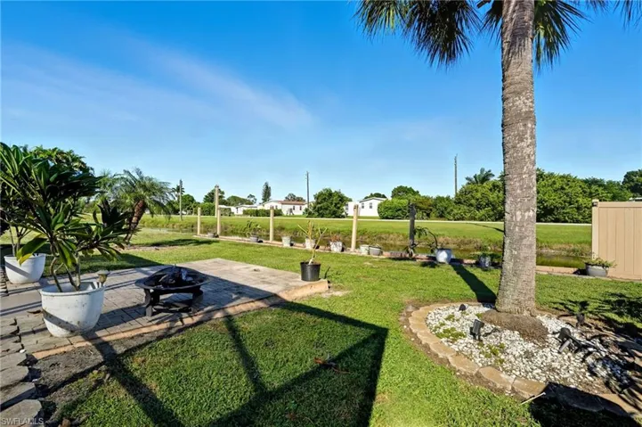 View of property's community with a patio, a fire pit, and a lawn