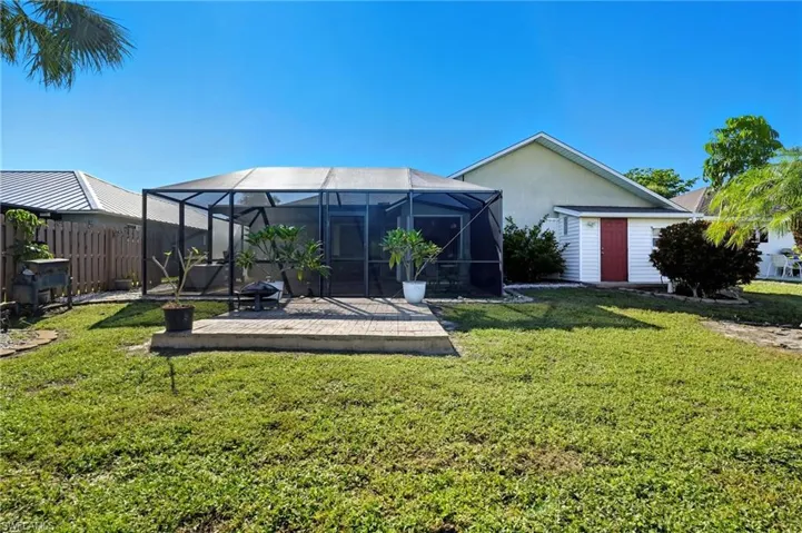 Rear view of house with a lanai, stucco siding, and a sunroom
