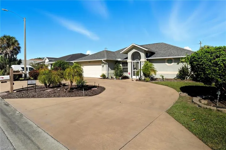 Single story home with a shingled roof, stucco siding, curved driveway, and a garage