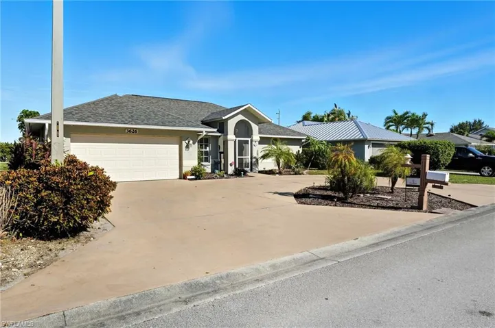 Ranch-style house featuring stucco siding, driveway, roof with shingles, and a garage
