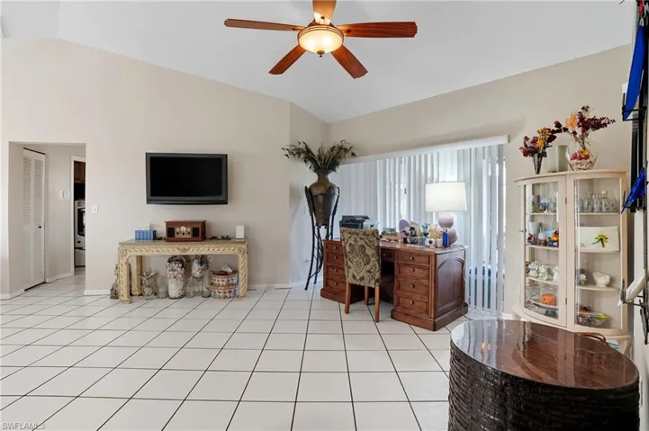 Office space featuring vaulted ceiling, a ceiling fan, and light tile patterned flooring