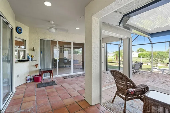 View of patio with a sunroom, ceiling fan, and glass enclosure