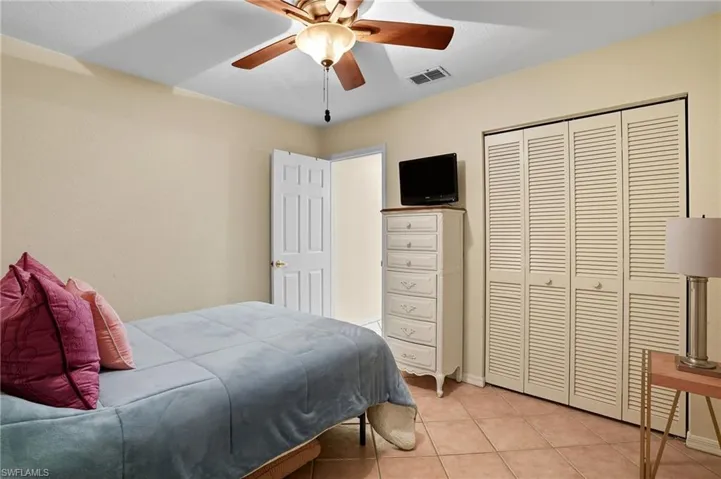 Bedroom with light tile patterned floors, a ceiling fan, and a closet