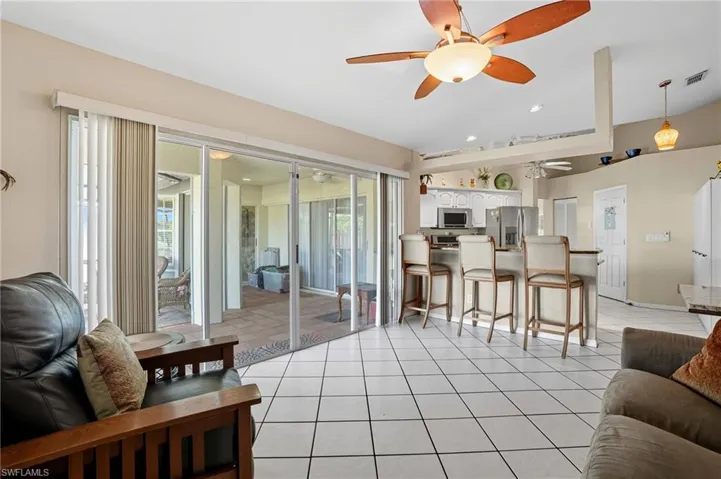 Living room with light tile patterned floors and recessed lighting