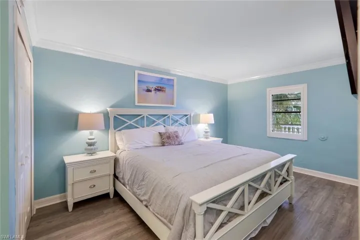 Bedroom with dark hardwood / wood-style flooring, a closet, and ornamental molding