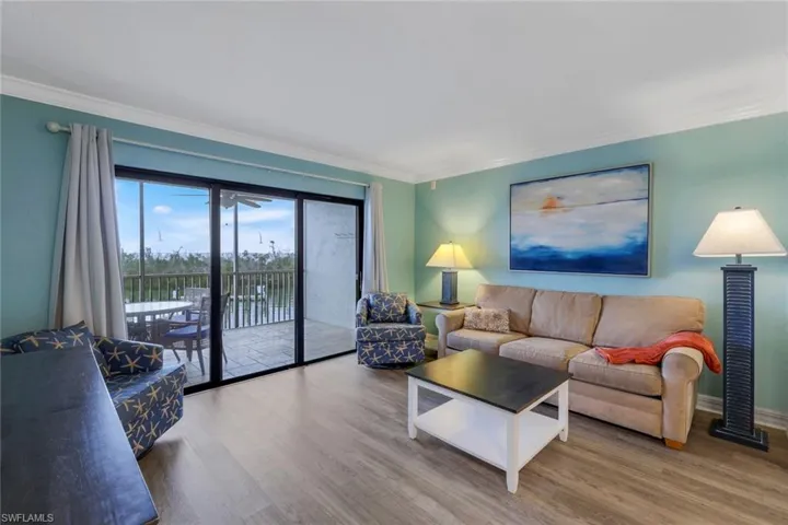 Living room with hardwood / wood-style flooring and ornamental molding