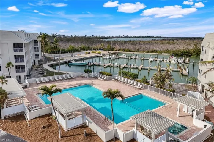 View of pool with a water view and a pergola