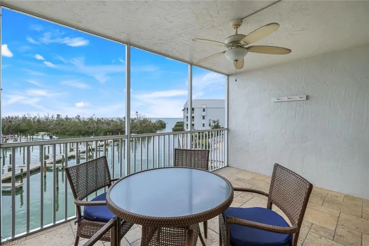 Sunroom / solarium with a water view and ceiling fan