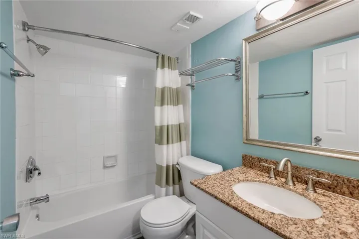 Full bathroom with toilet, vanity, and shower / bath combo