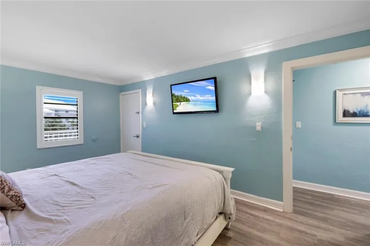 Bedroom with hardwood / wood-style flooring and ornamental molding