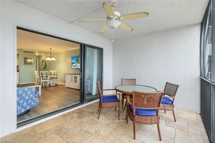 Sunroom featuring ceiling fan with notable chandelier