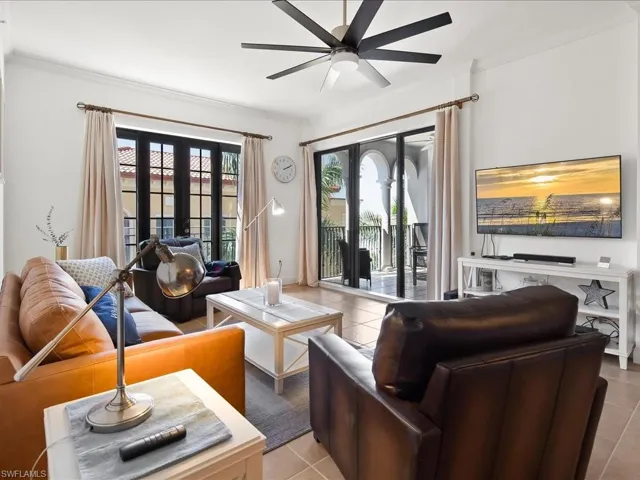 Living room with ornamental molding, ceiling fan, light tile patterned flooring, and french doors