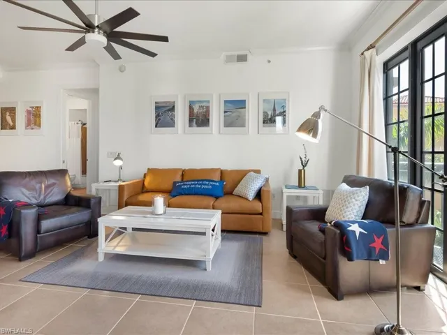 Living area with crown molding, tile patterned floors, and a ceiling fan
