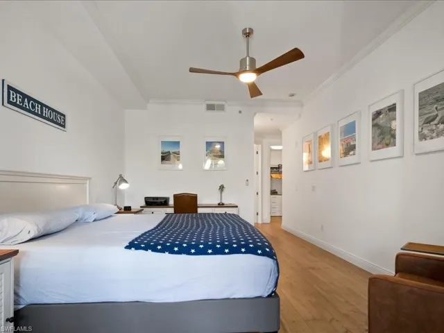 Bedroom featuring wood finished floors, ornamental molding, and ceiling fan