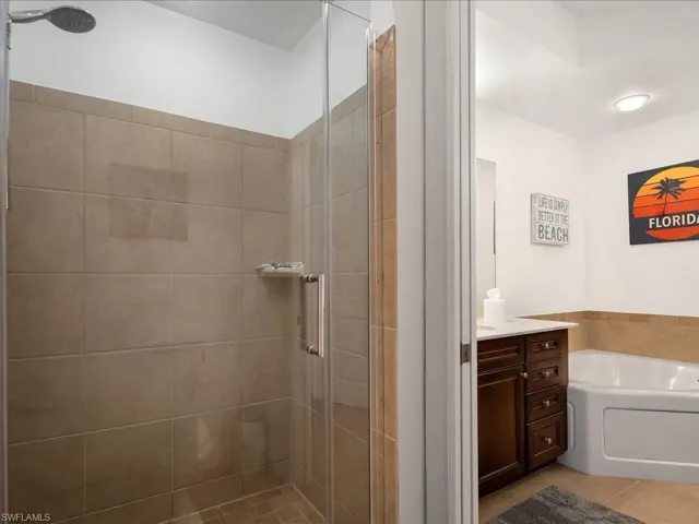 Bathroom with vanity, a shower stall, a bath, and light tile patterned flooring
