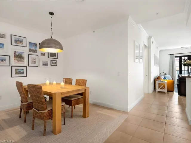 Dining area featuring ornamental molding and light tile patterned flooring