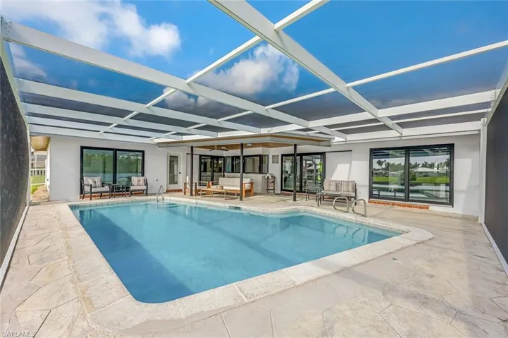 View of pool with a lanai, a patio area, and an outdoor hangout area