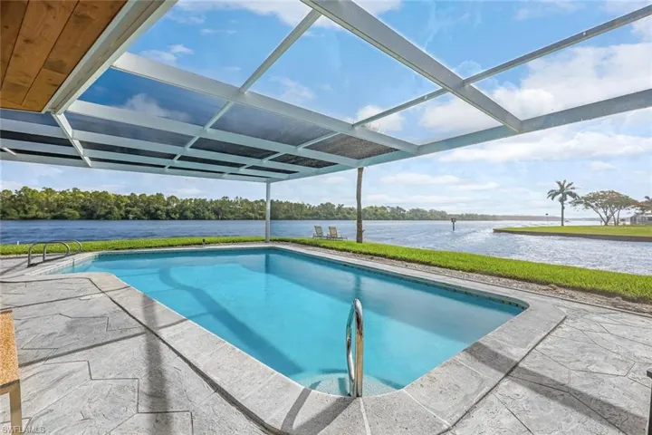 View of pool featuring a water view, a lanai, and a patio area