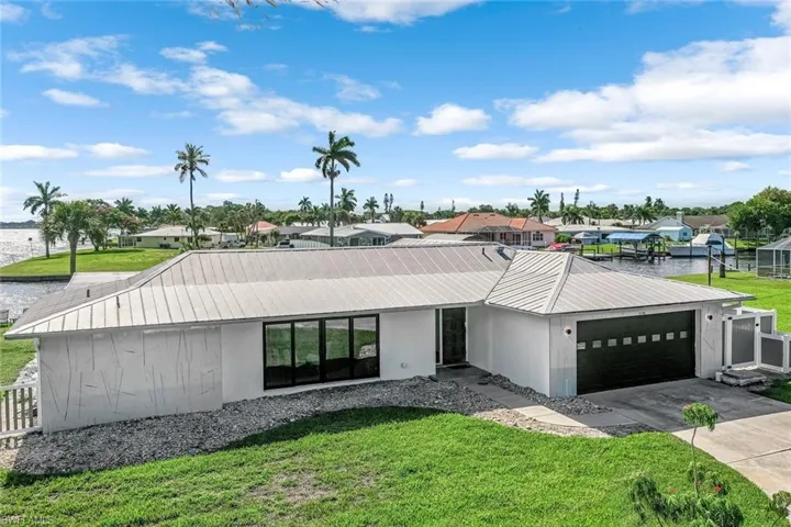 View of front facade featuring a garage and a front lawn