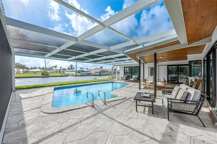 View of swimming pool with a patio and a lanai
