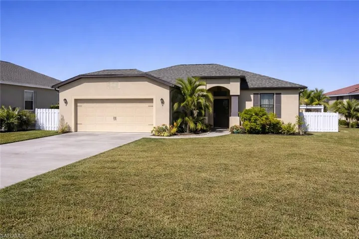 Ranch-style house featuring stucco siding, driveway, and a garage