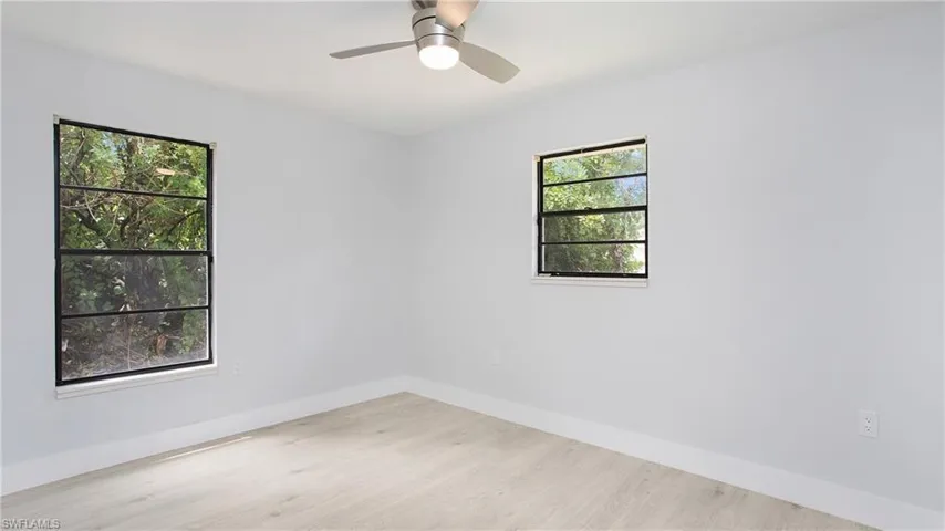 Unfurnished room featuring plenty of natural light, ceiling fan, and light hardwood / wood-style floors
