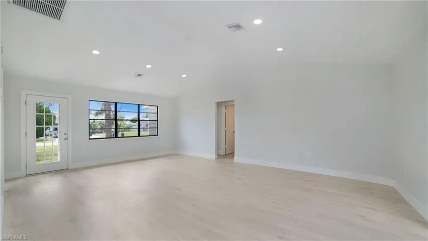 Empty room featuring lofted ceiling and light hardwood / wood-style flooring. Think of the possibilities! Same angle as the staged picture.