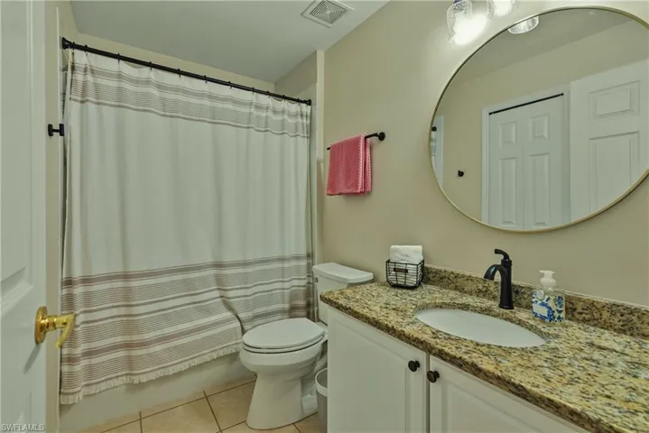 Full bathroom with vanity, light tile patterned flooring, and shower / bathtub combination with curtain