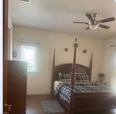 Bedroom featuring wood finished floors, a ceiling fan, and a textured ceiling