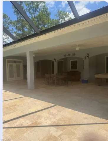 Rear view of property with a patio area, a lanai, and french doors