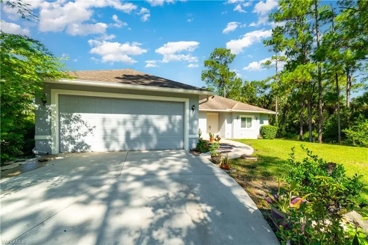 Single story home with a front lawn, stucco siding, driveway, a garage, and a shingled roof