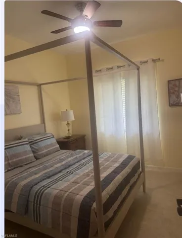 Carpeted bedroom with a ceiling fan