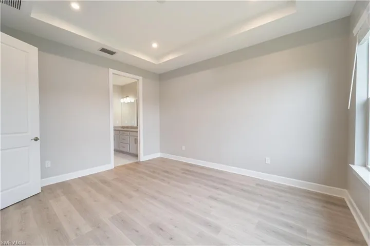 Spare room featuring light hardwood / wood-style flooring and a raised ceiling