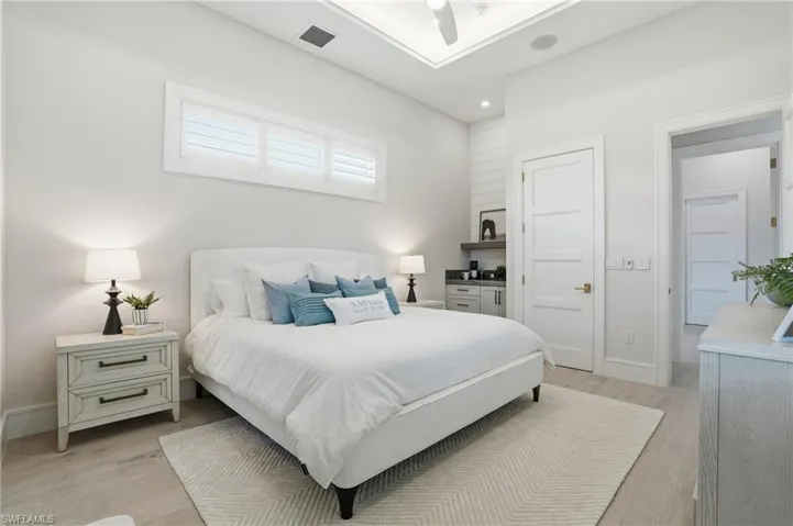 Bedroom with light wood-style floors, ceiling fan, and recessed lighting
