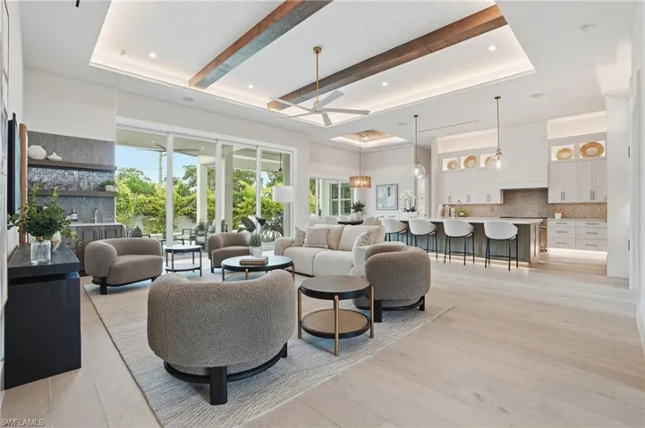 Living area with ceiling fan, light wood-style flooring, recessed lighting, and a wood ceiling with exposed beams