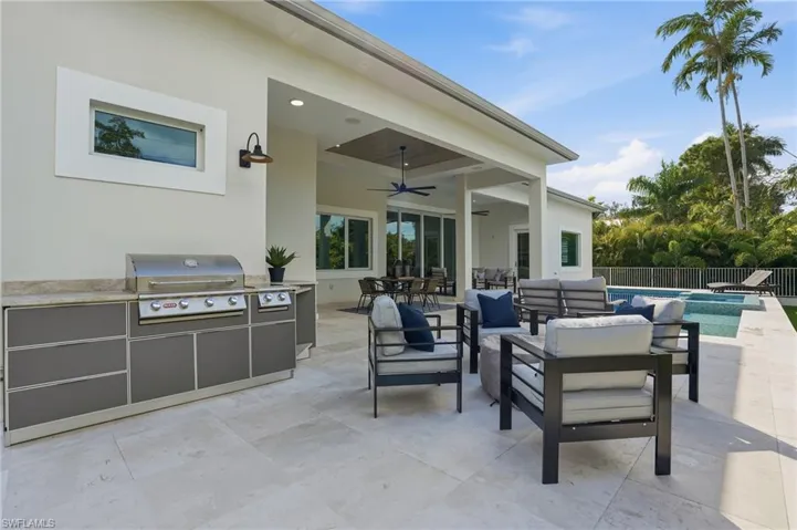 View of patio / terrace featuring an outdoor living / dining area, ceiling fan, and an outdoor kitchen
